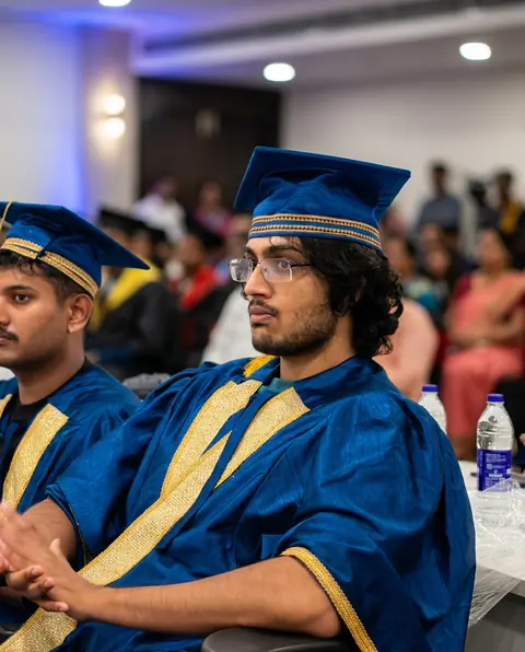 A graduate in a blue convocation robe and cap at the ceremony